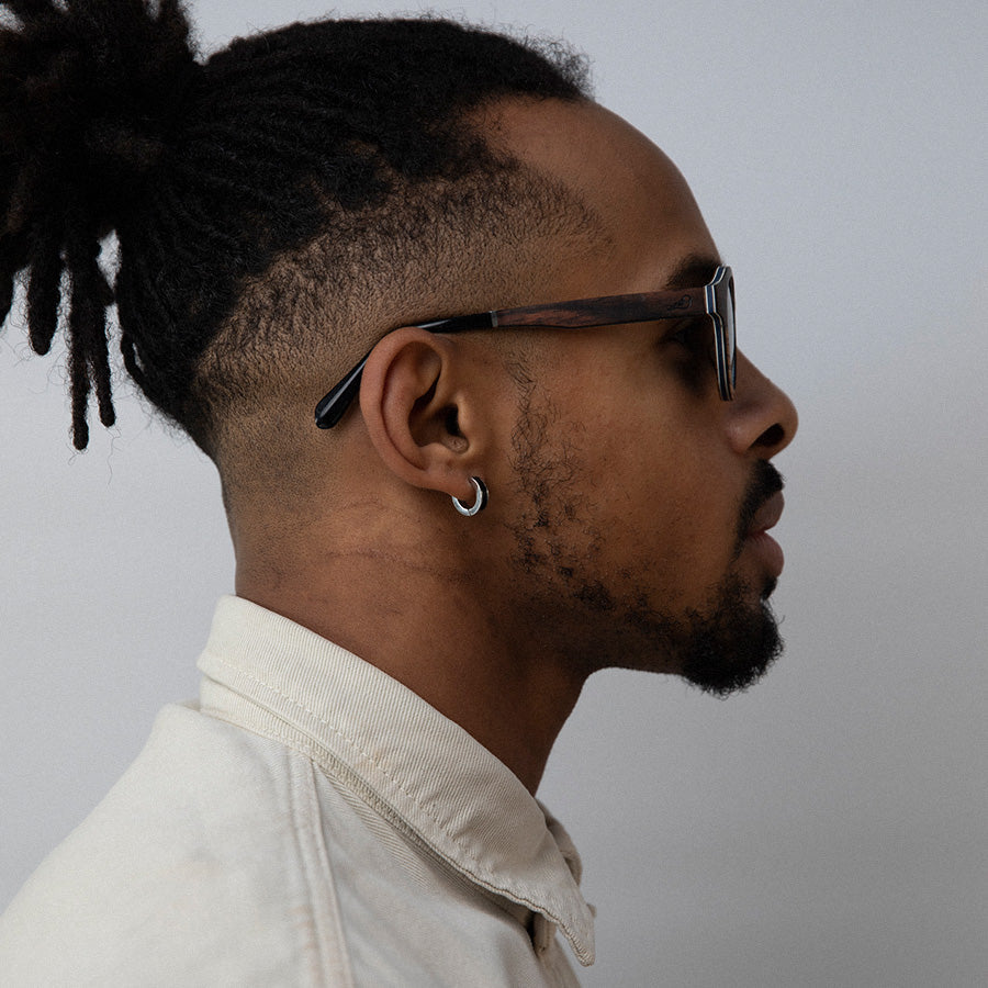 Black man wearing eco friendly round wooden sunglasses with polarised lenses facing sideways