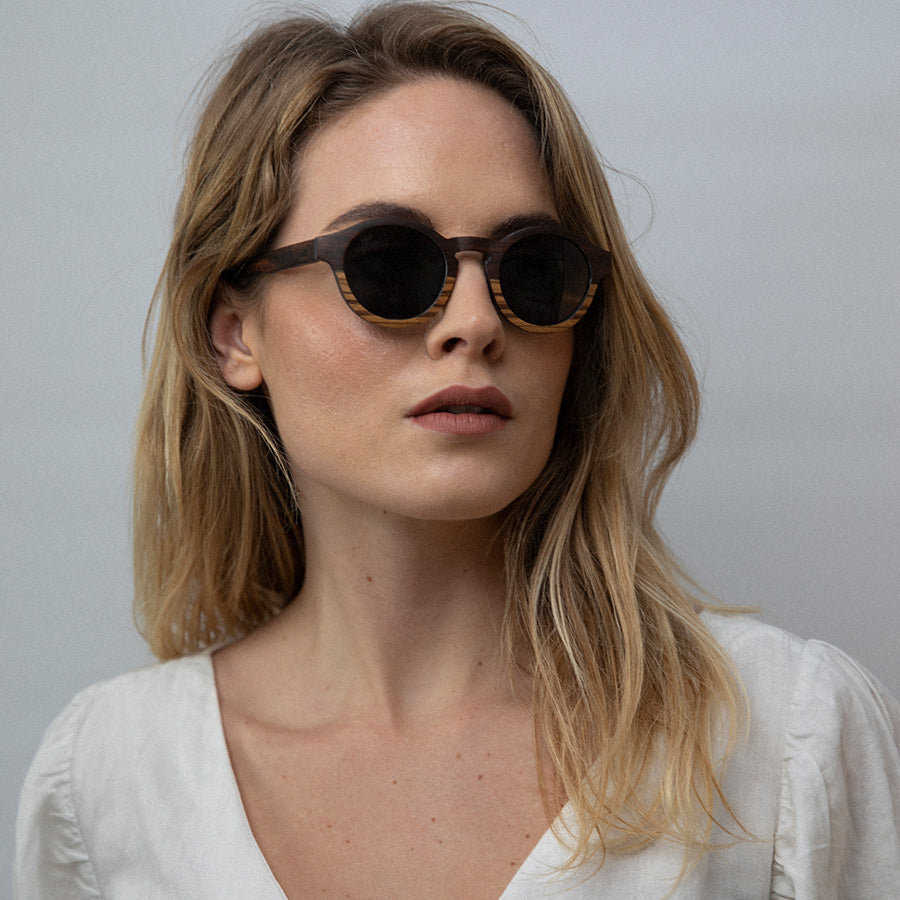 Woman wearing eco friendly round wooden sunglasses with polarised lenses