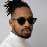 Black man wearing clear grey frame sunglasses with polarised lenses