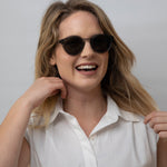 Woman wearing clear grey frame sunglasses with polarised lenses