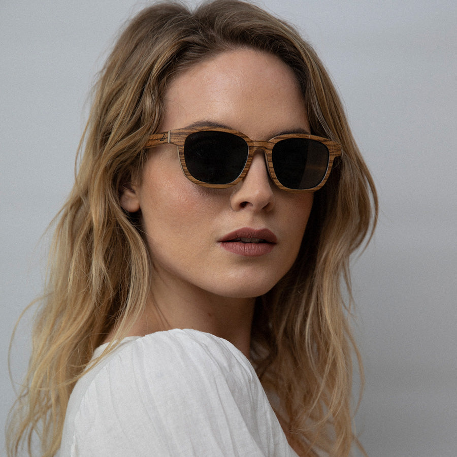 Woman wearingEco conscious wooden sunglasses with light coloured wood