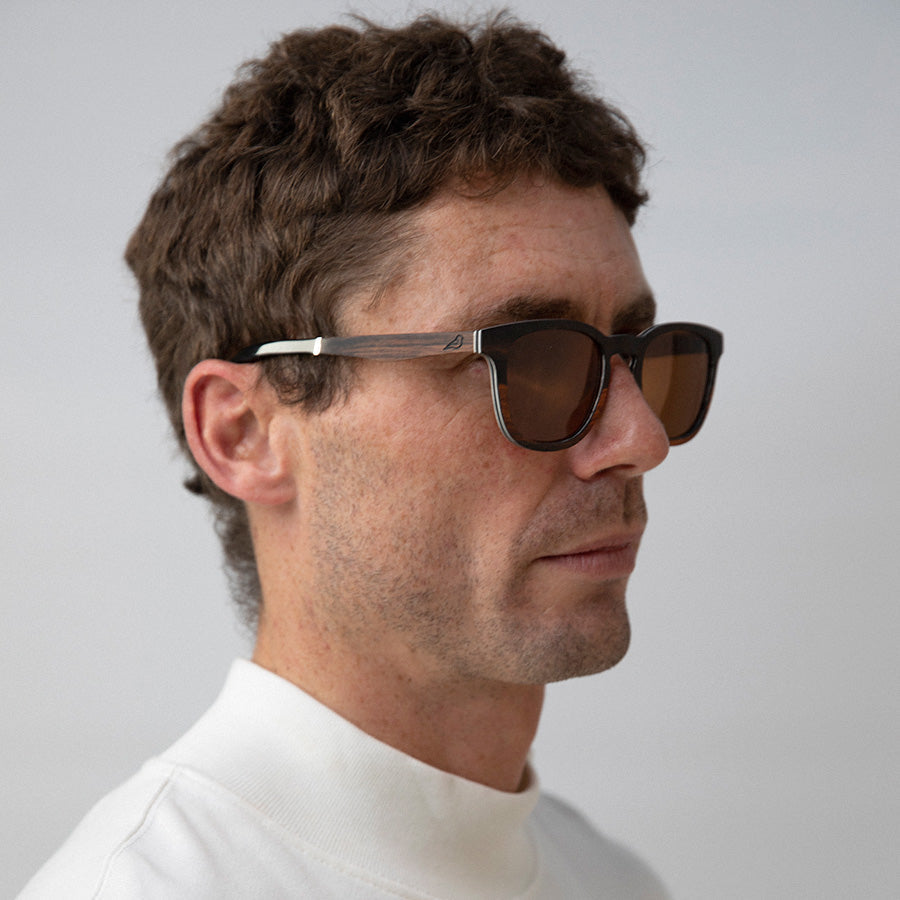 Man wearing Black and red wooden sunglasseslooking sideways