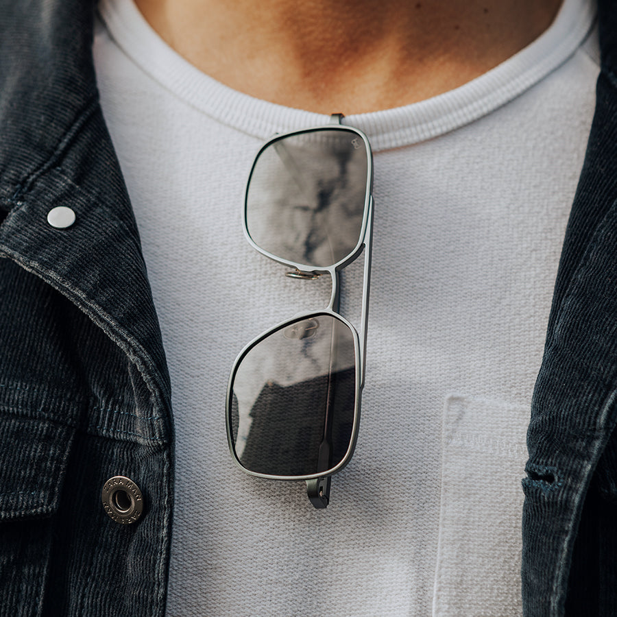 Large square metal sunglasses tucked into a tshirt