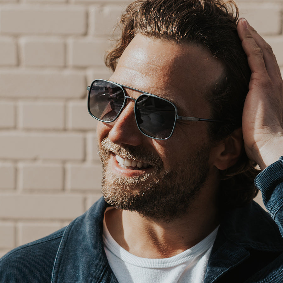 Man outside wearing large square metal sunglassesin the sun